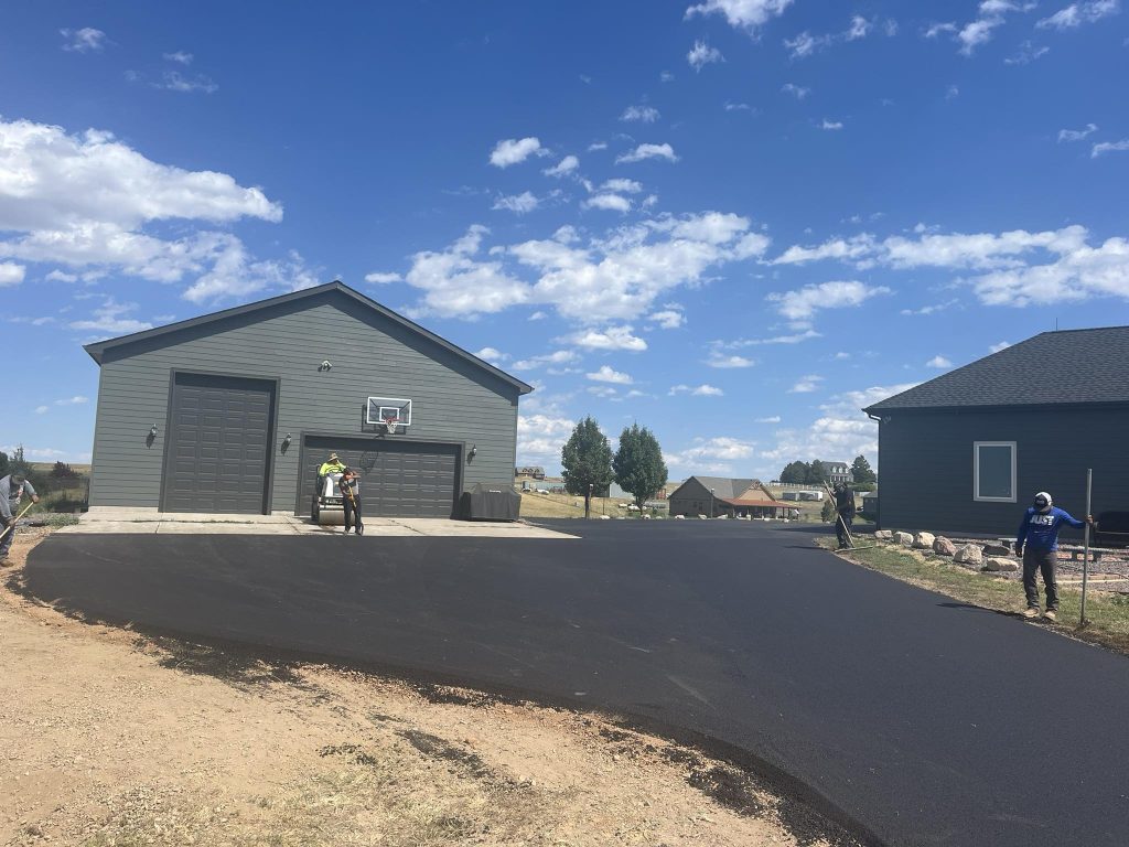 asphalt driveway being installed to a detached garage
