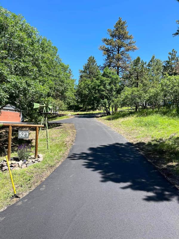 New asphalt driveway winds through foothills to remote house