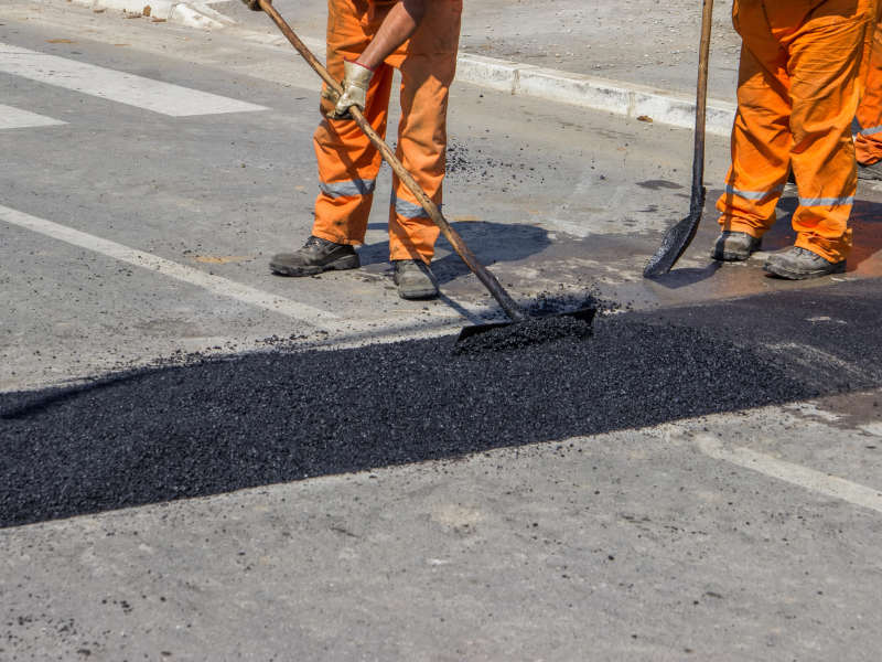 a long utility cut being patched with asphalt