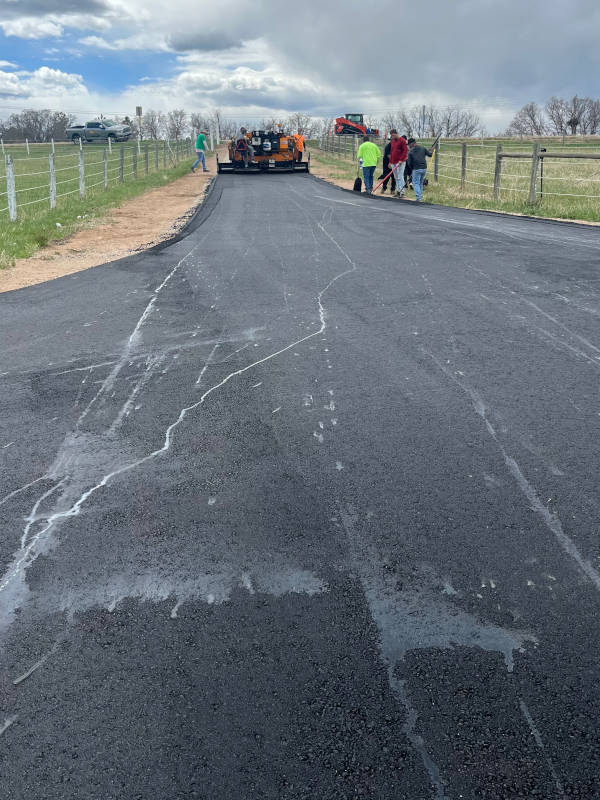 paver laying hot asphalt on new driveway