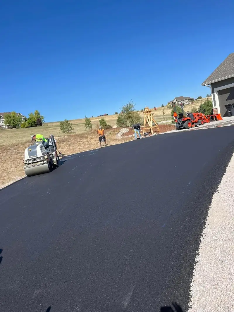 Finishing touches being put on an asphalt driveway